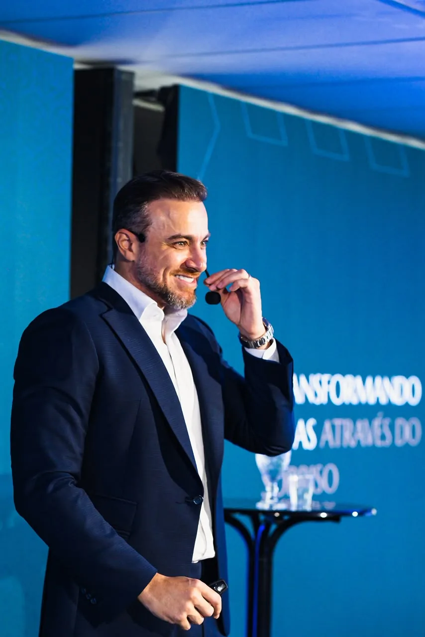 Dr. Rogério Penna no palco, de microfone